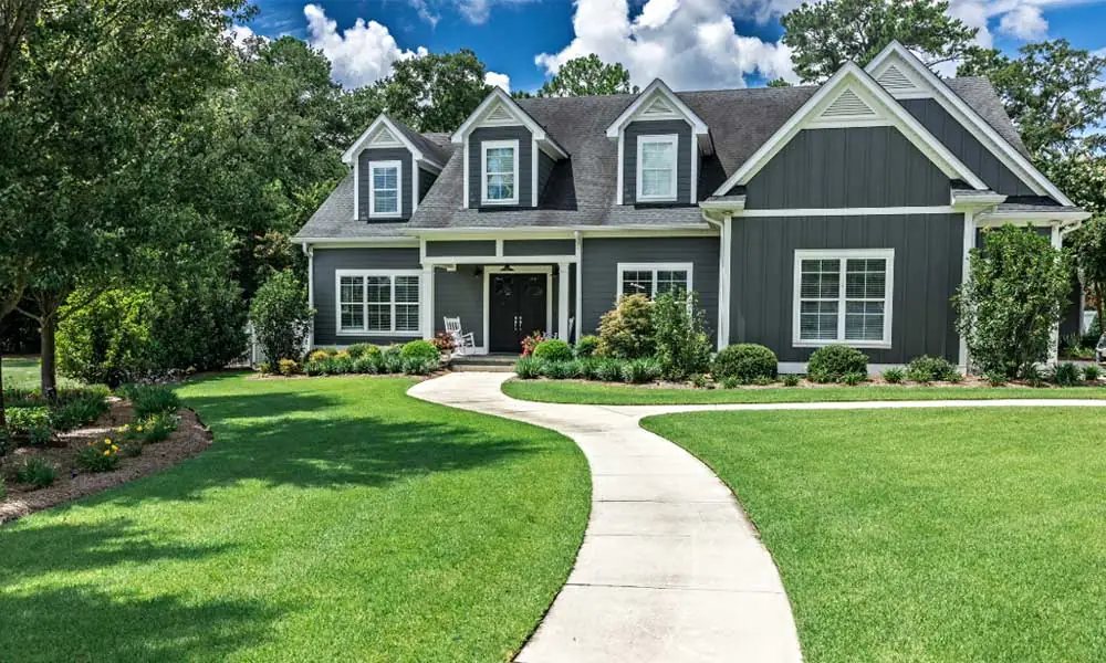 Grey House with green grass in the front yard