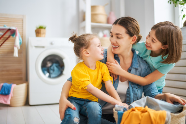 Mom and daughters doing laundry together. 