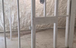 G&S Insulating closed-cell spray foam insulation on an exterior wall behind interior stud framing with a header and electrical wiring in Little Rock, AR.