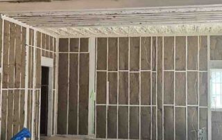 G&S Insulating rock wool batt insulation in ceiling joists and surrounding walls of an open room in Little Rock, AR.