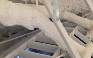 G&S Insulating spray foam insulation on the ceiling deck, sealing a pipe penetration above radial ceiling framing in Little Rock, AR.